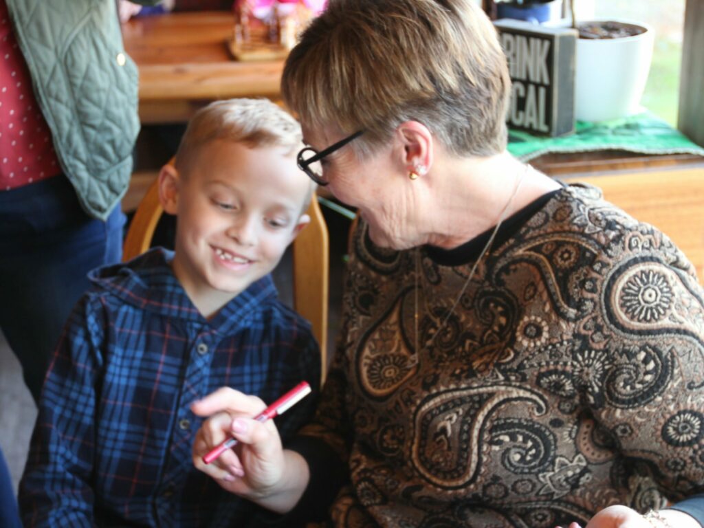 Deanna Nowadnick with her grandson at the book signing party for Bouquet of Wisdom
